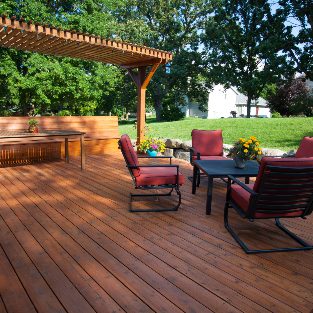 House exterior being painted, covered with plastic sheeting and marked with tape. White picket fence, red door.