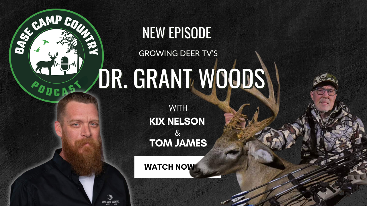 A man with a beard is holding a deer in front of a sign that says dr grant woods
