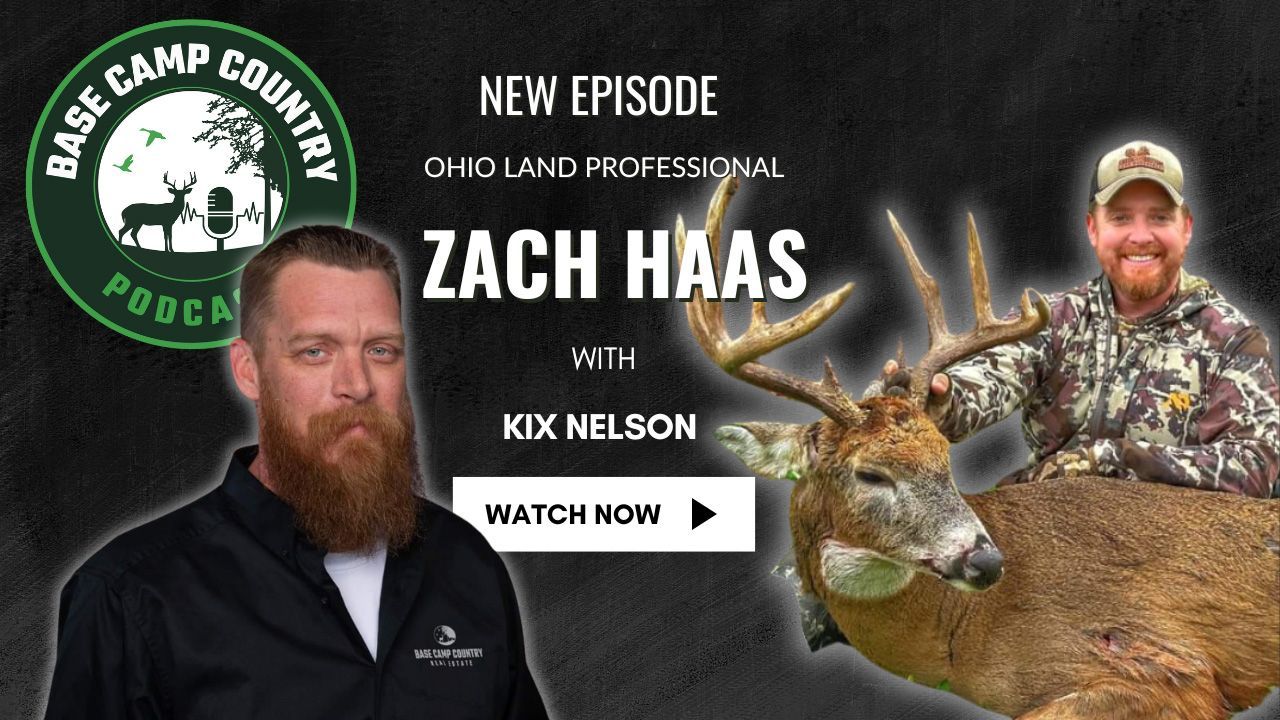 A man with a beard is standing next to a large deer.