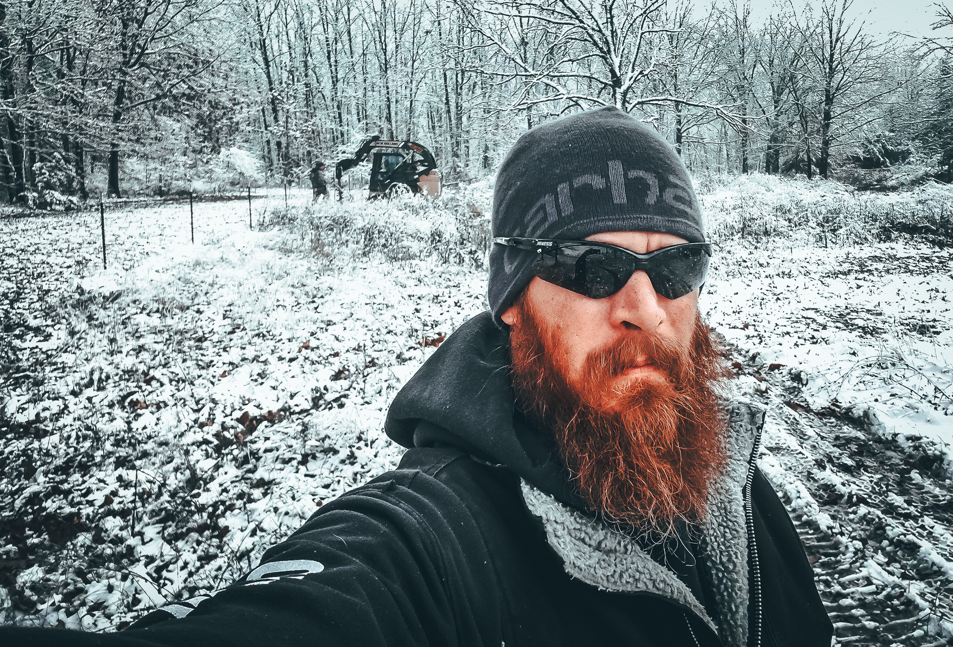 A man with a beard is taking a selfie in the snow.