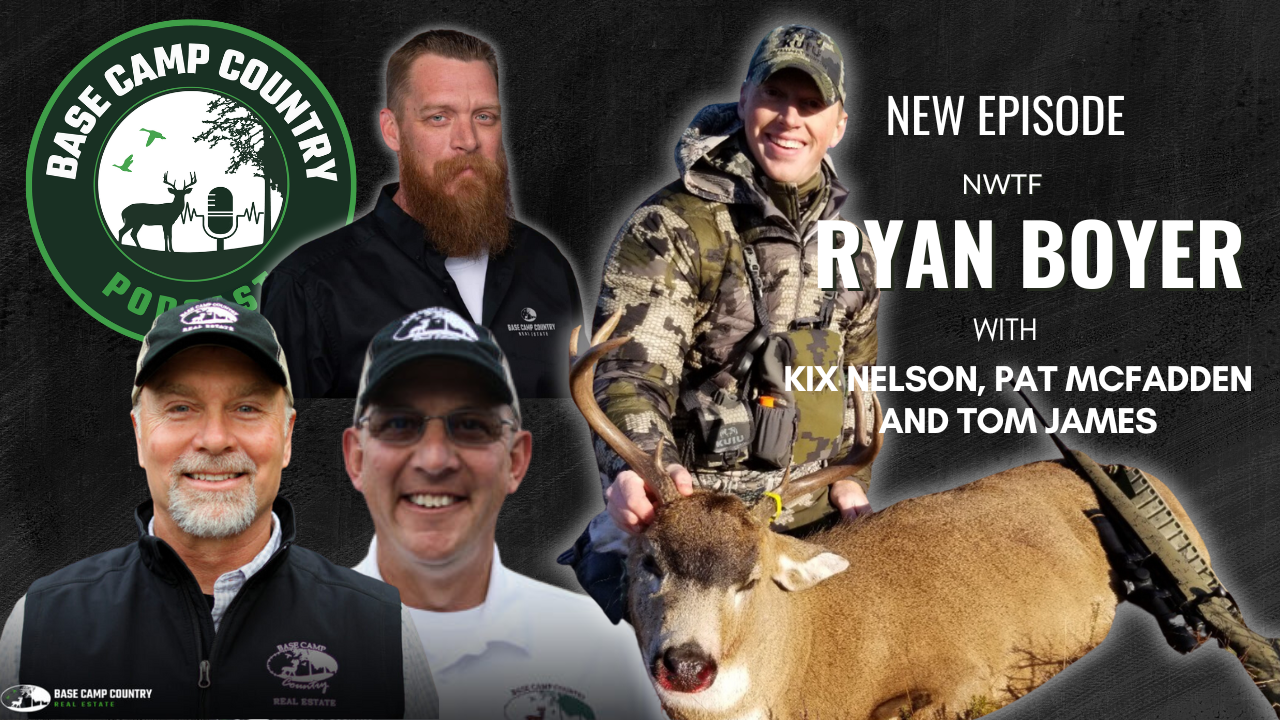 A group of men are posing for a picture with a deer in the background