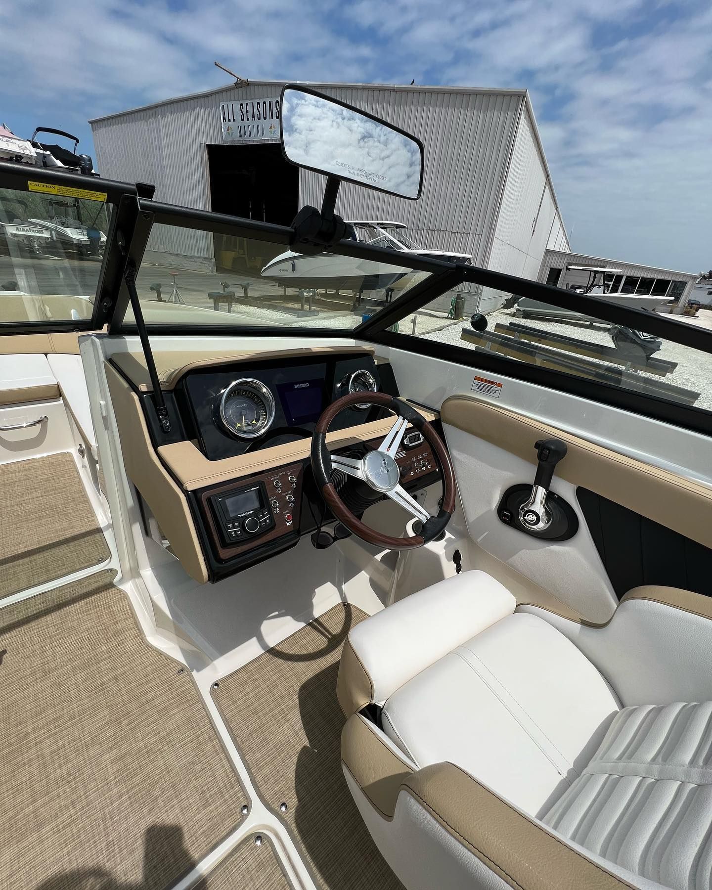 The inside of a boat with a steering wheel and a dashboard.