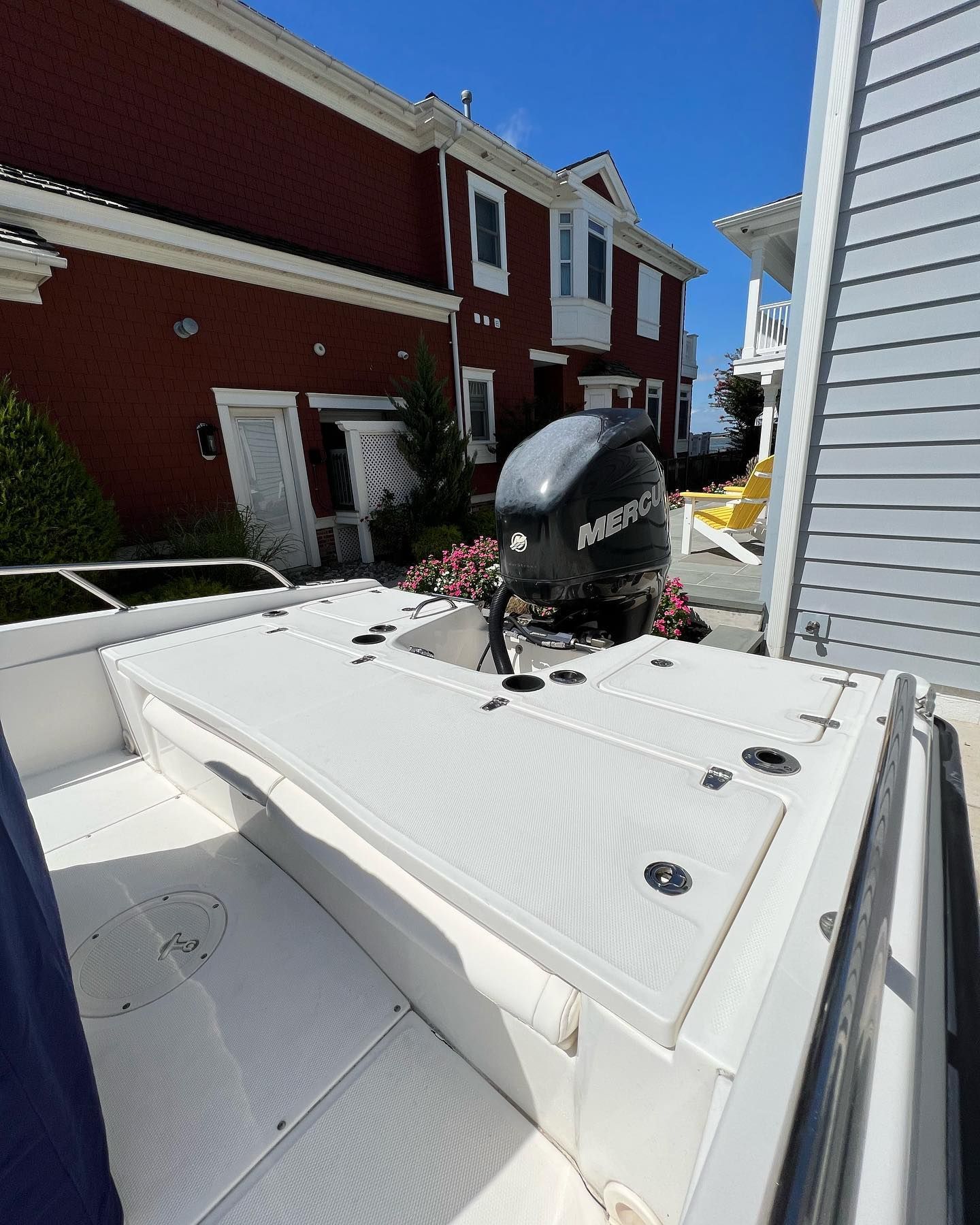 A white boat with a mercury outboard motor on the deck
