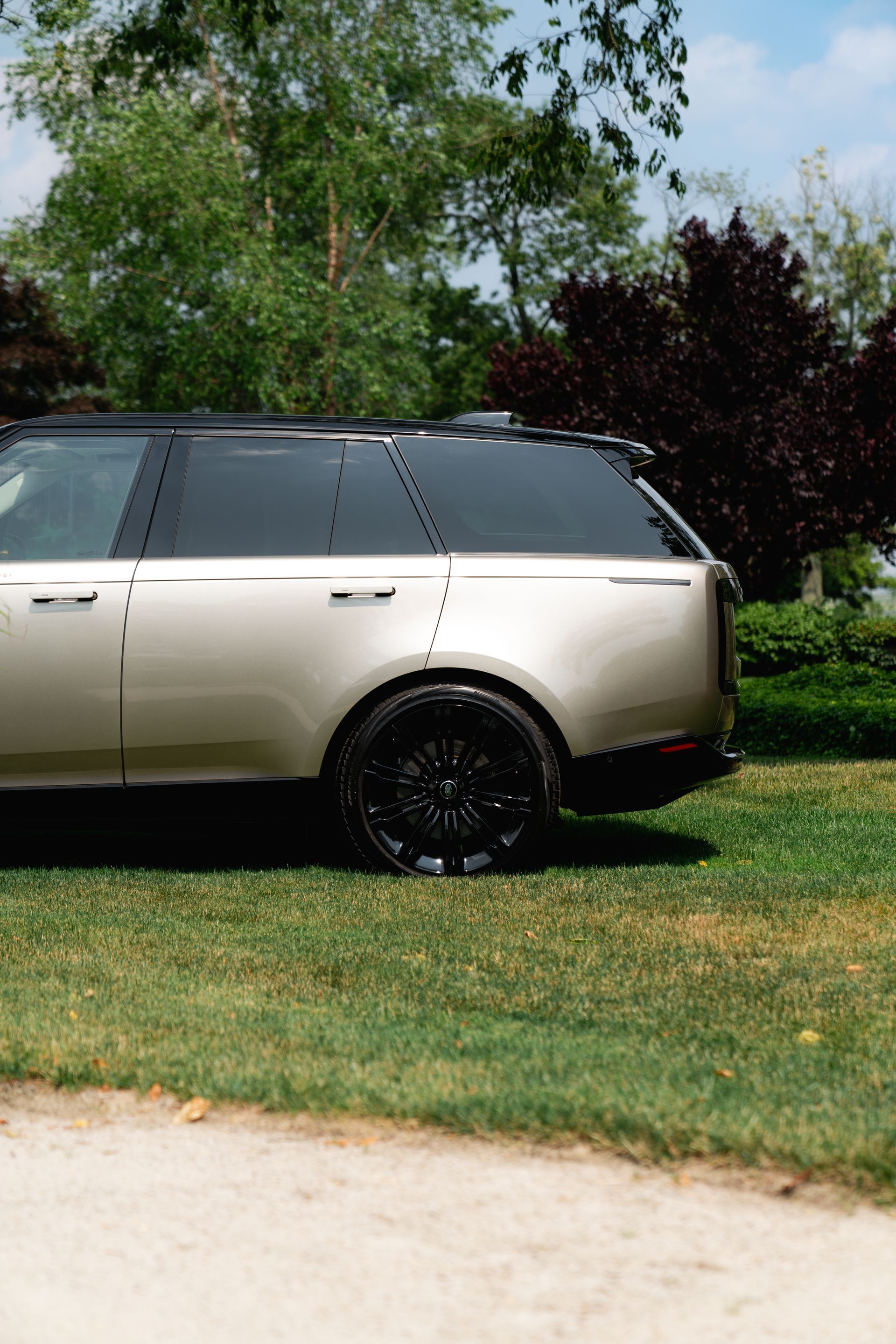 A silver suv is parked in a grassy field.