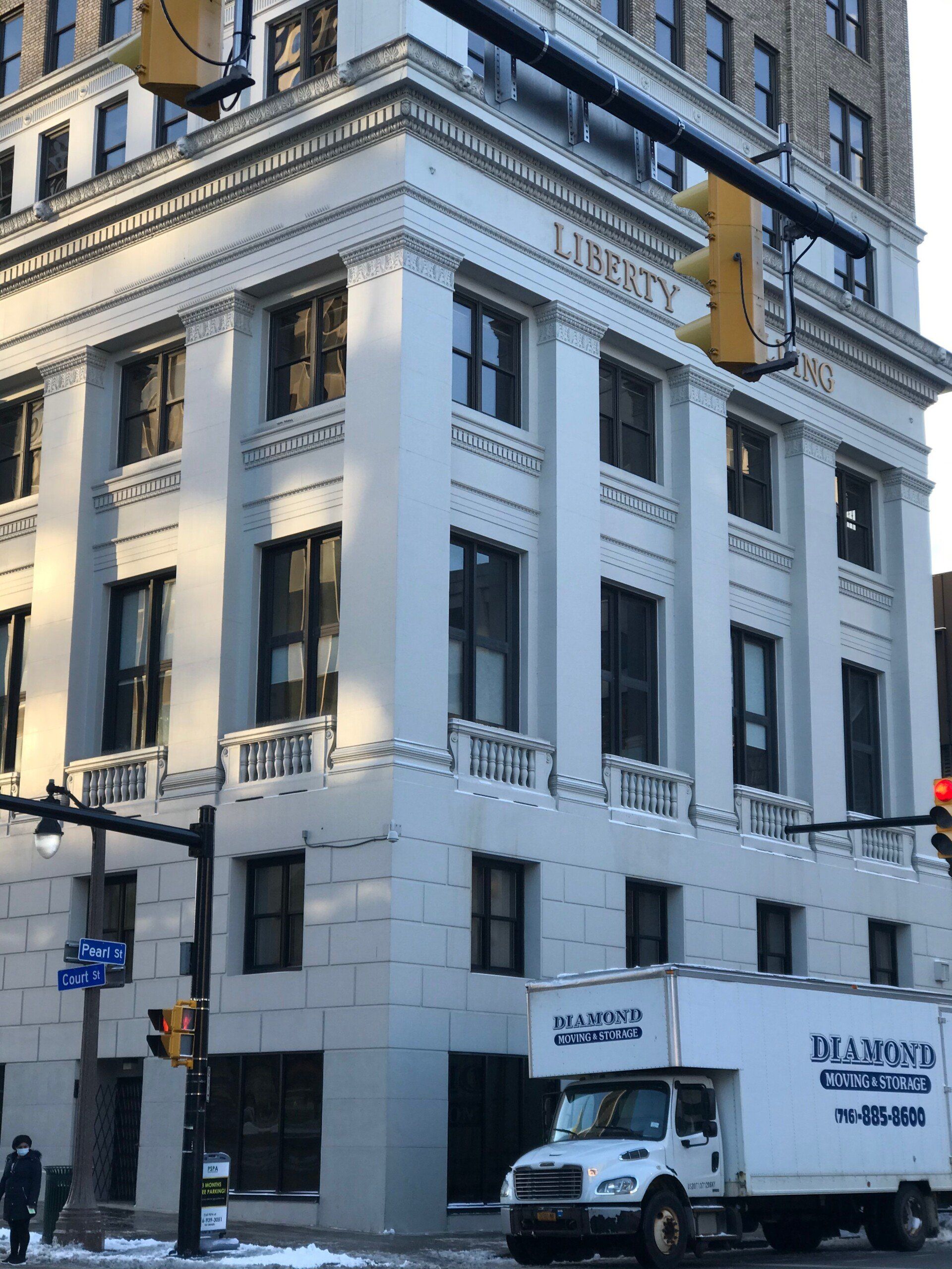 Two Male Workers Carrying Carpet And Cardboard Boxes