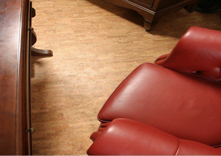 A red leather chair is sitting on a cork floor