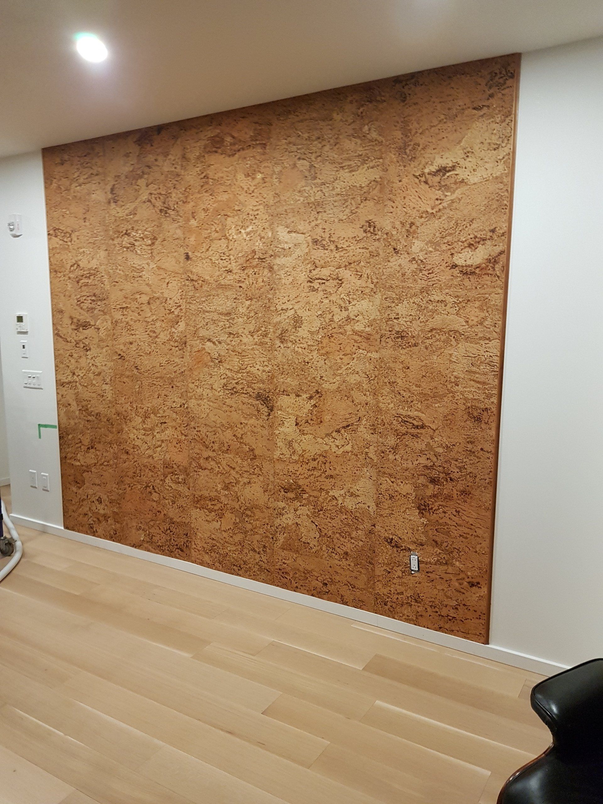 A cork wall is being installed in a living room.