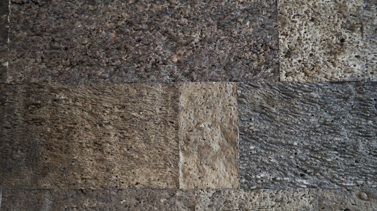 A close up of a brick wall with a gray and brown texture.