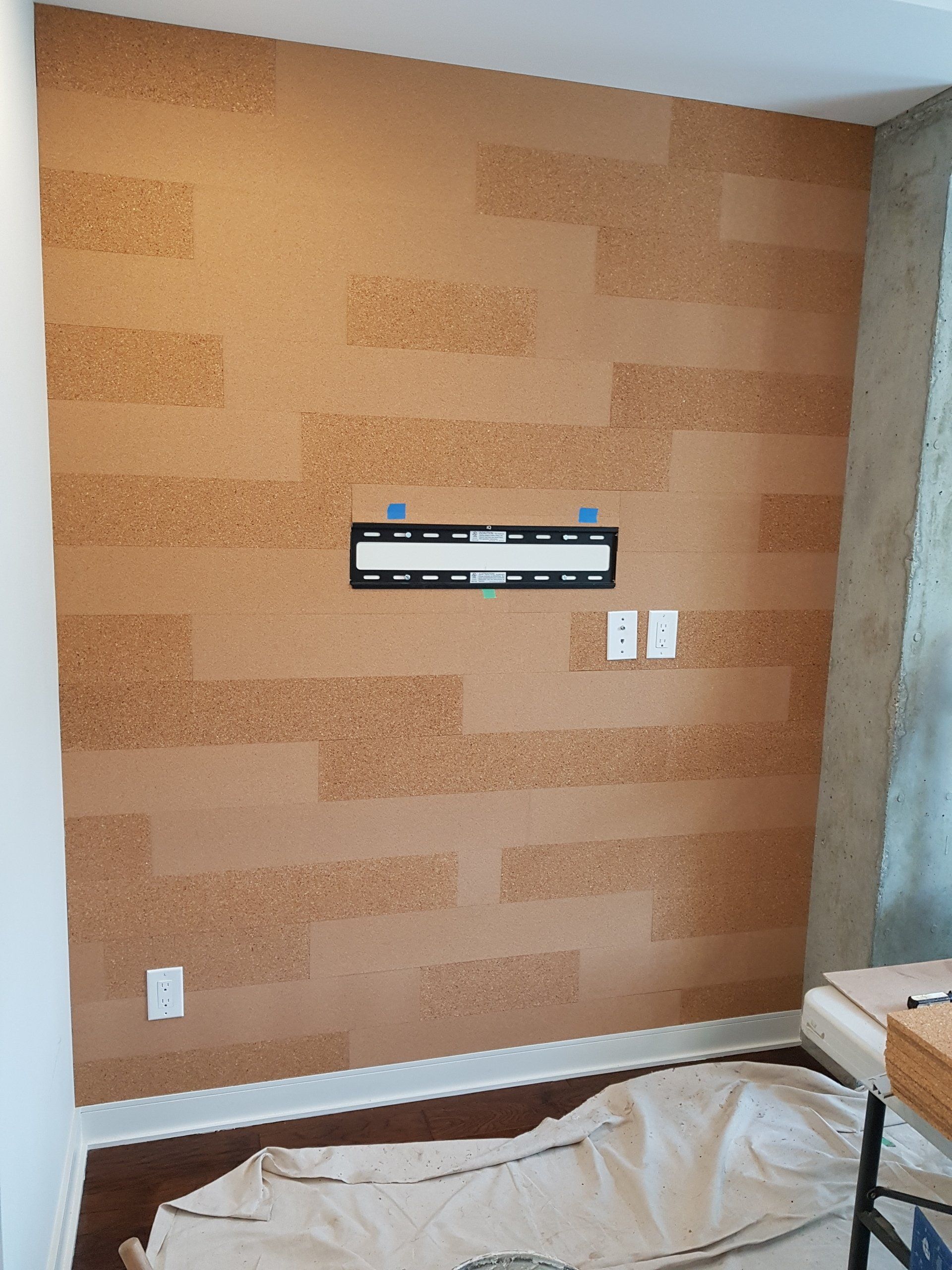 Un mur en liège avec un support TV dessus