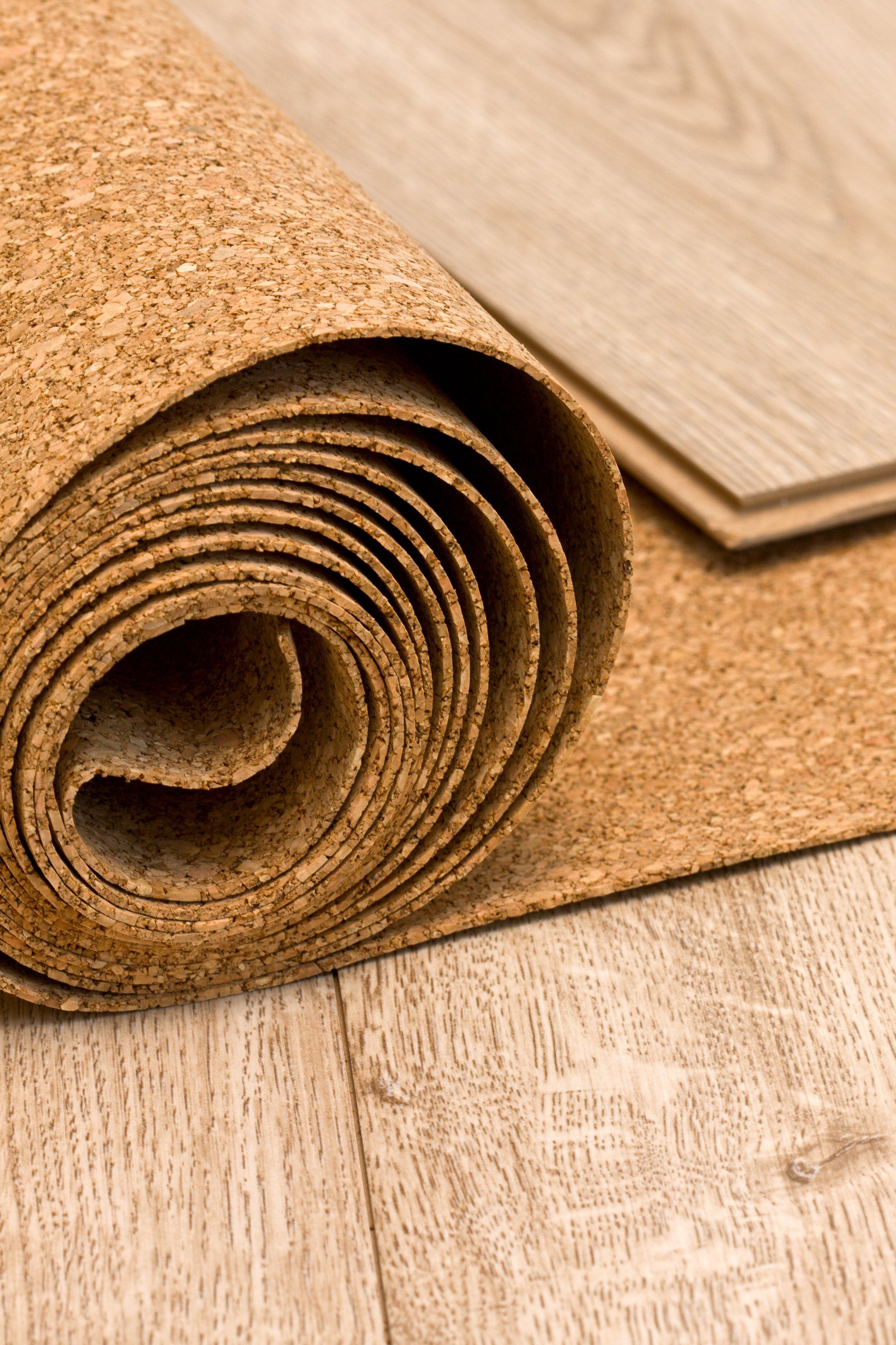 A roll of cork is sitting on top of a wooden floor.