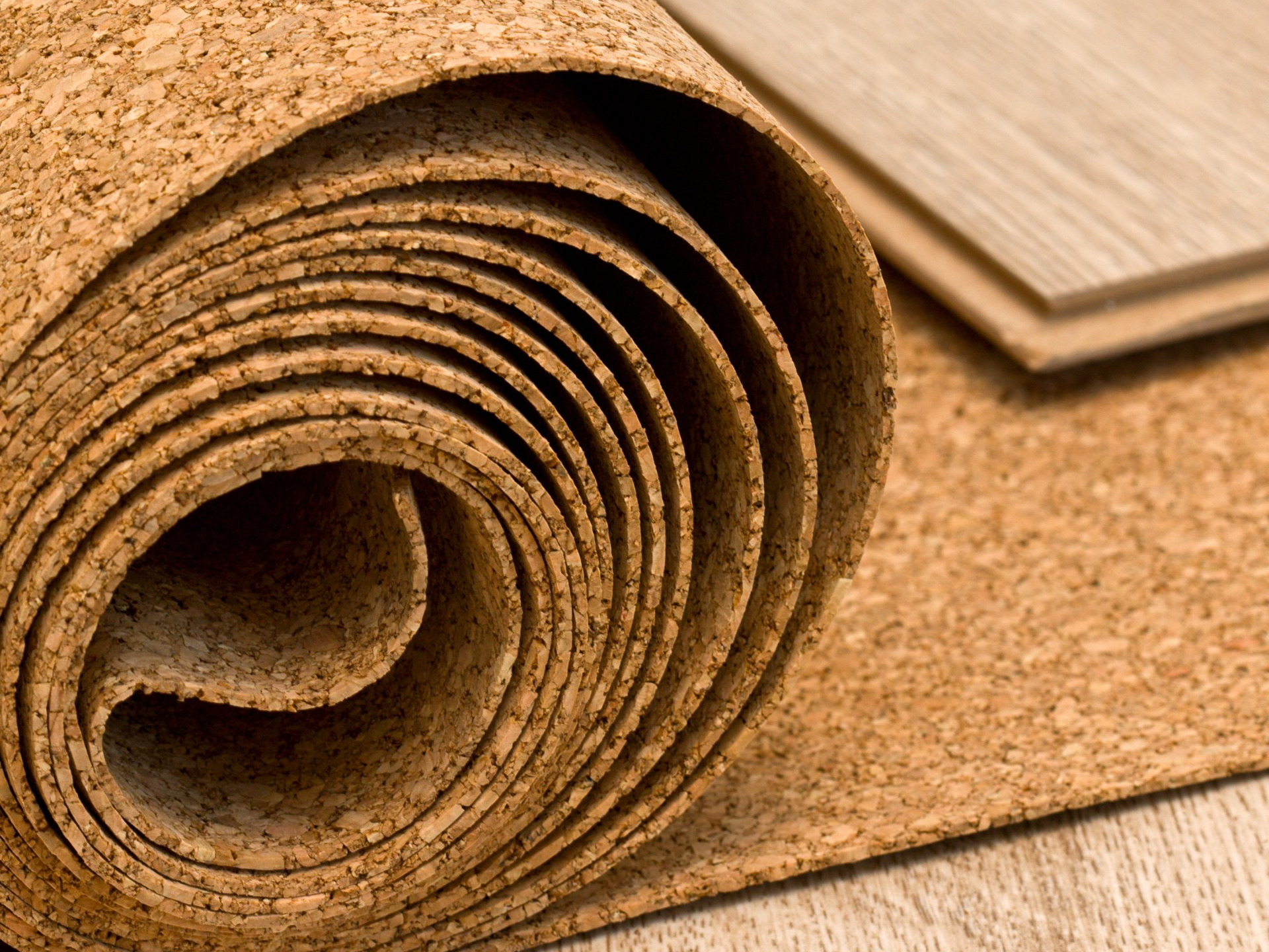 A roll of cork is sitting on top of a wooden floor.