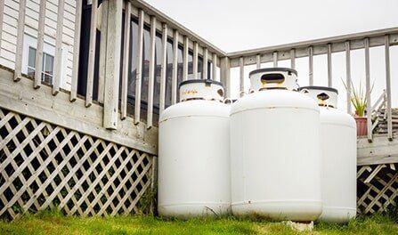 Gas Cylinders On Grass — Propane Gas in Delta, CO Gas Cylinders On Grass — Propane Gas in Delta, CO