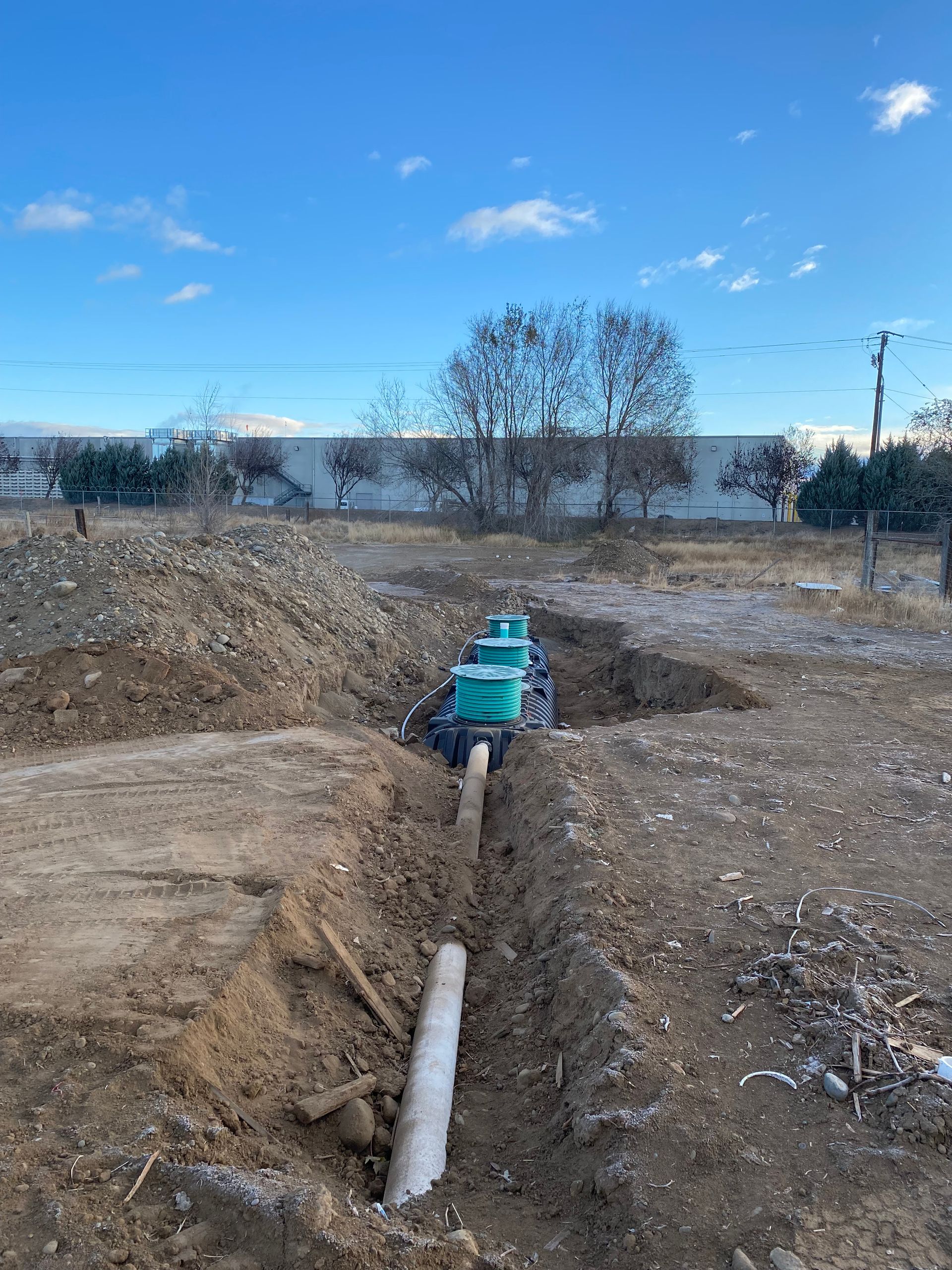 A pipe is being installed in the dirt in a field.