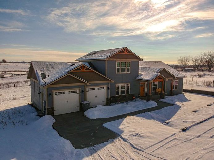 An aerial view of a large house covered in snow.