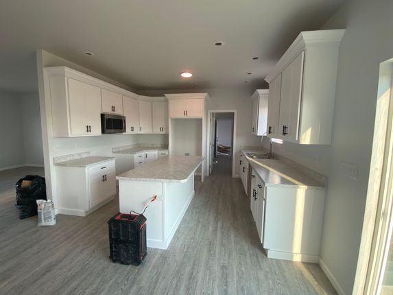 A kitchen with white cabinets and a large island.