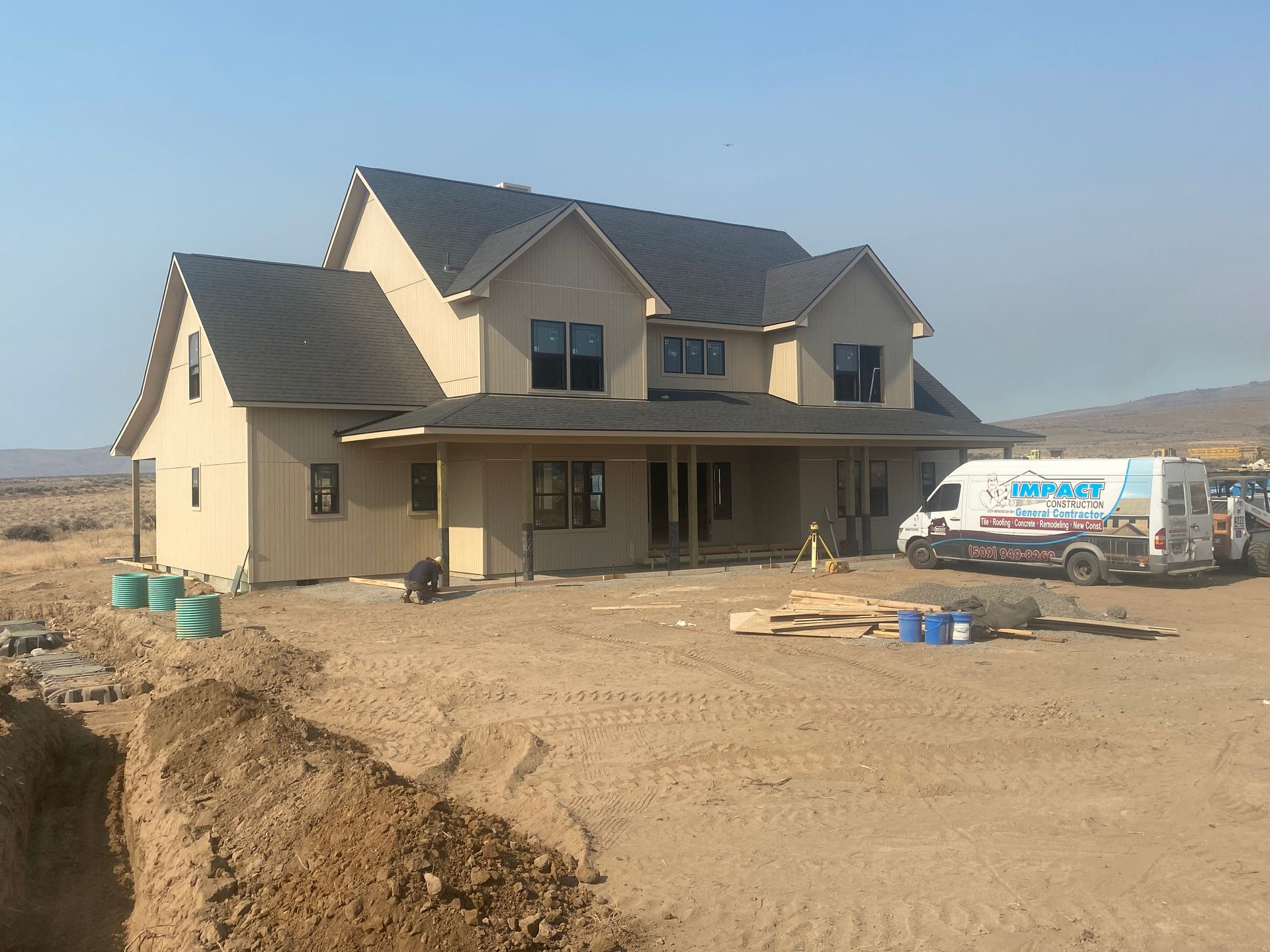 A house is being built in the desert with a minnet van parked in front of it