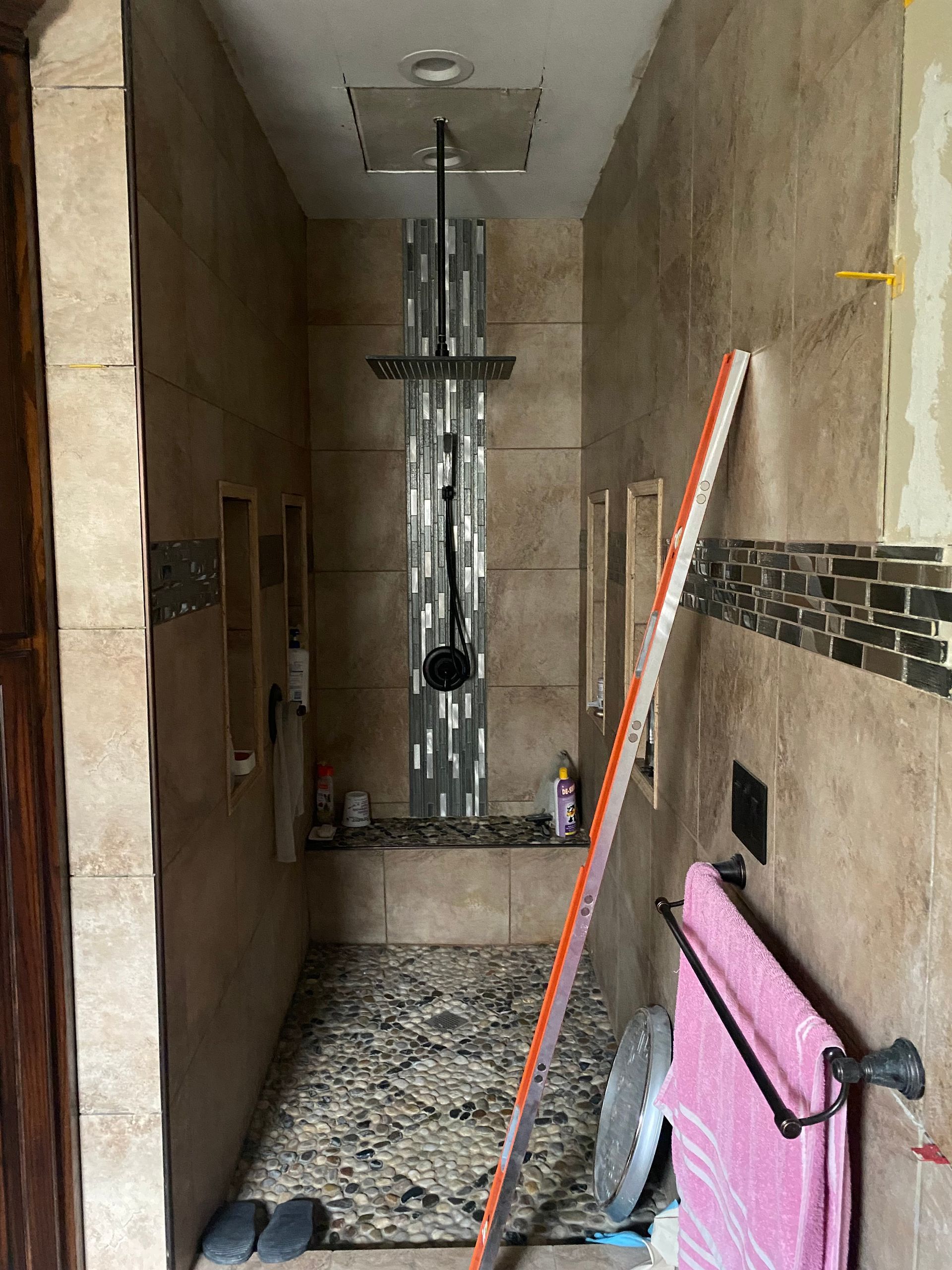 A bathroom with a walk in shower and a towel rack.