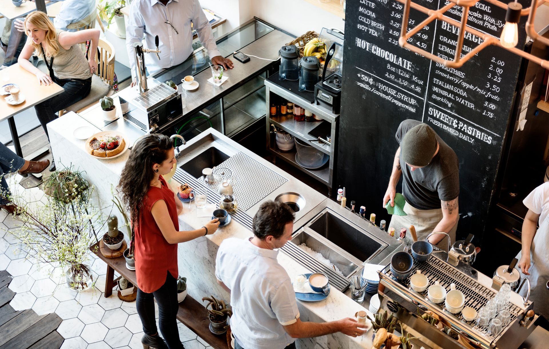 People ordering coffee and working in a modern cafe.