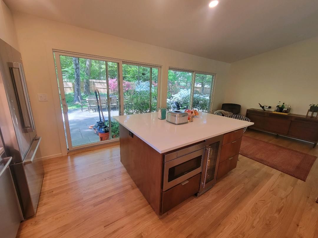 Two men are cleaning a kitchen with a bucket and a ladder.