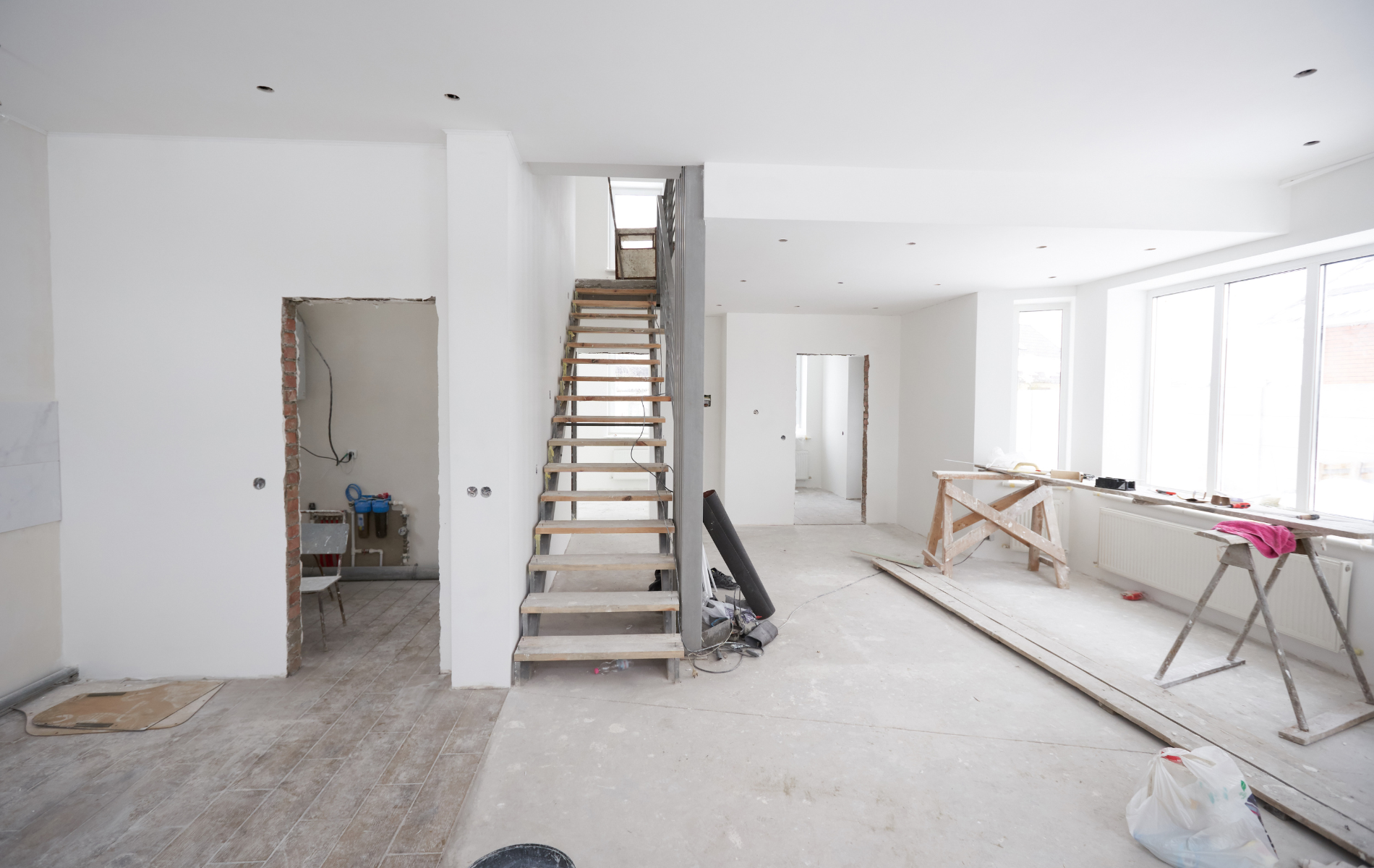 An empty room with a wooden staircase going up to the second floor.