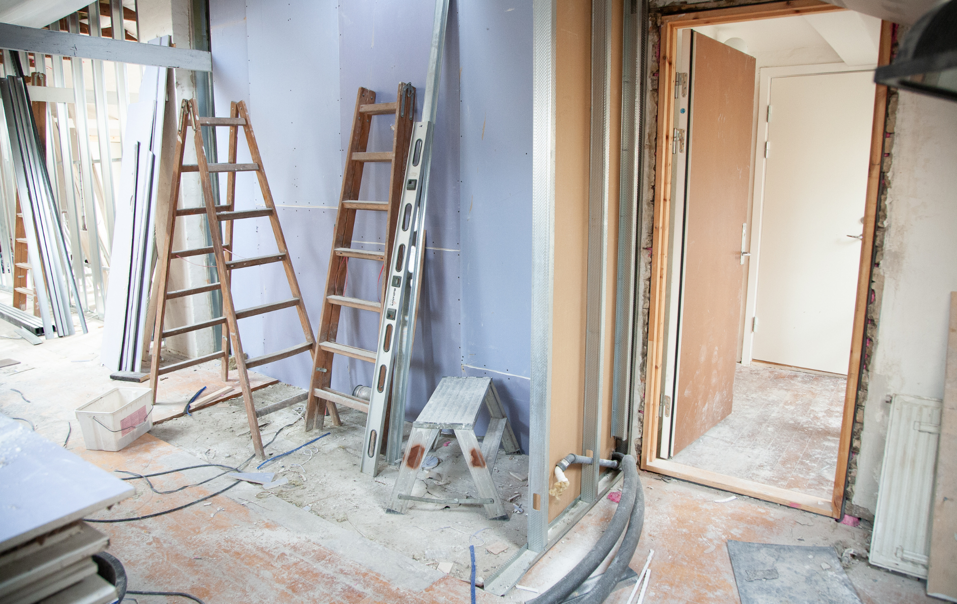 A room under construction with a ladder and a stool