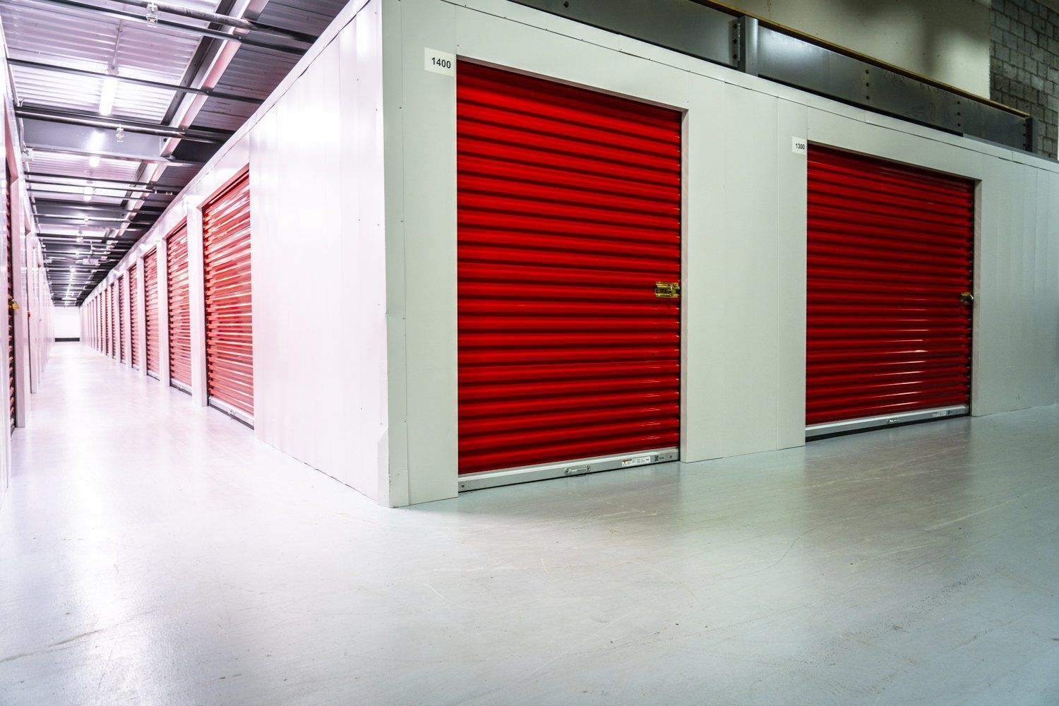 une rangée d unités de stockage avec des portes rouges dans un entrepôt.