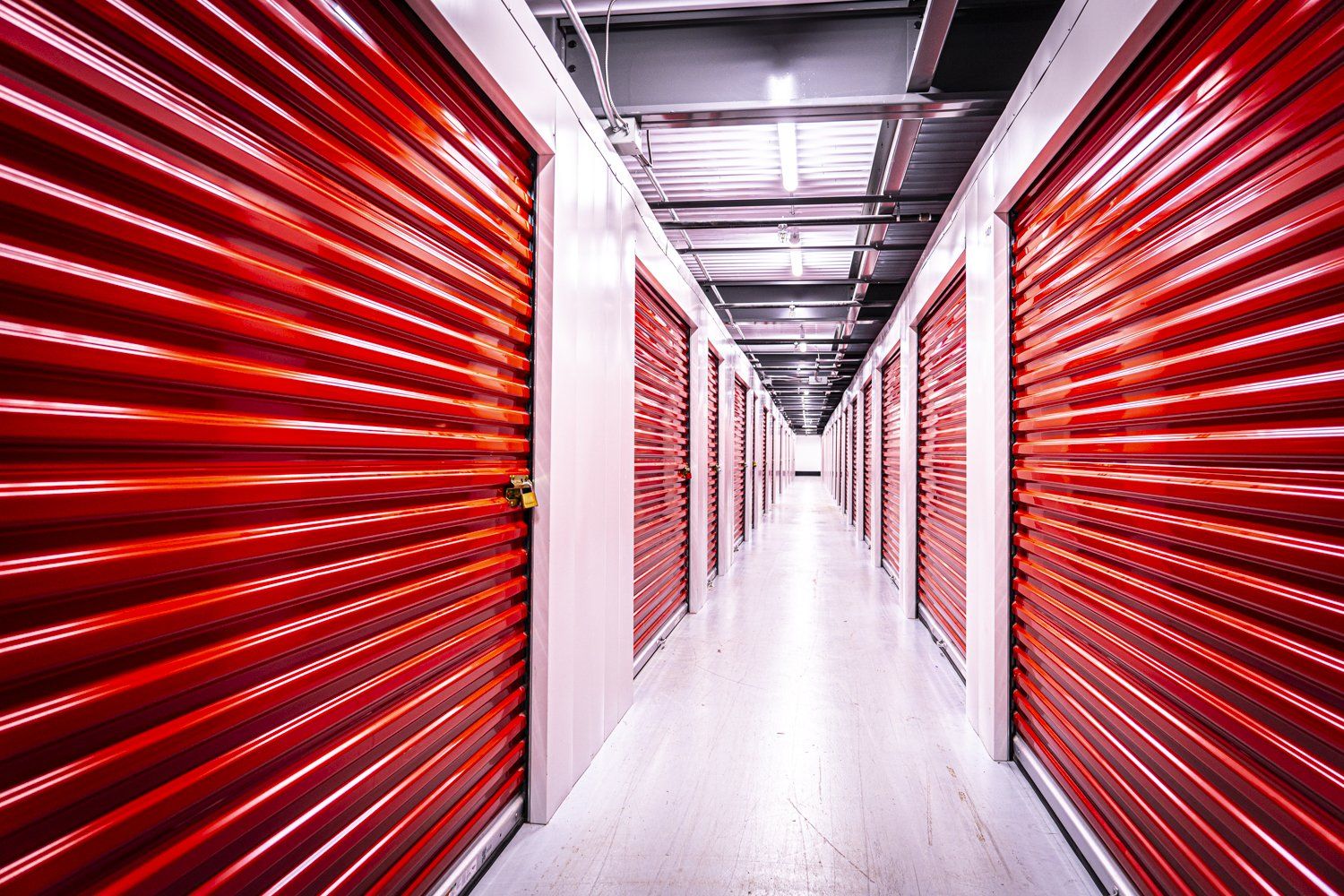un long couloir avec des portes rouges dans un entrepôt.