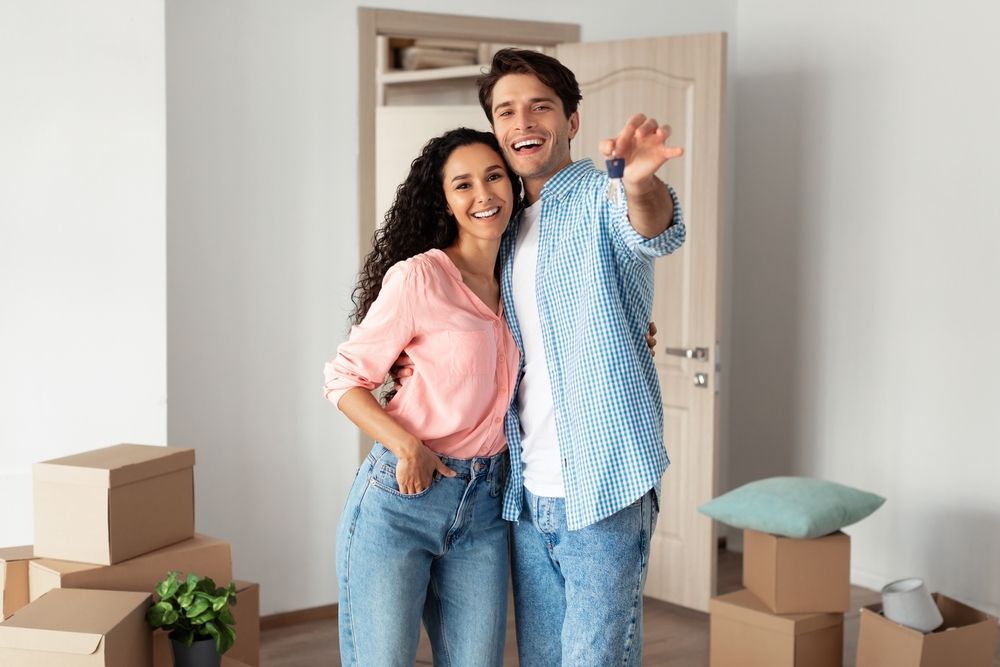 un homme et une femme posent pour une photo dans leur nouvelle maison.