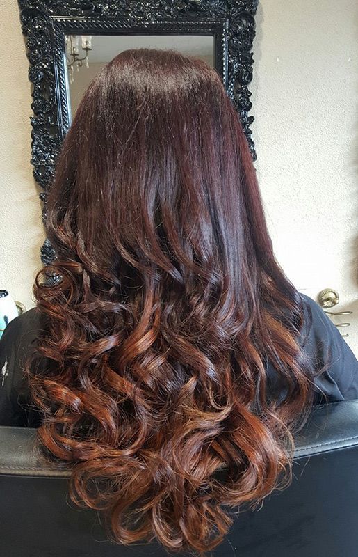 A Woman with Long Brown Hair Is Sitting in Front of A Mirror — Capello Hair Design in Port Macquarie, NSW