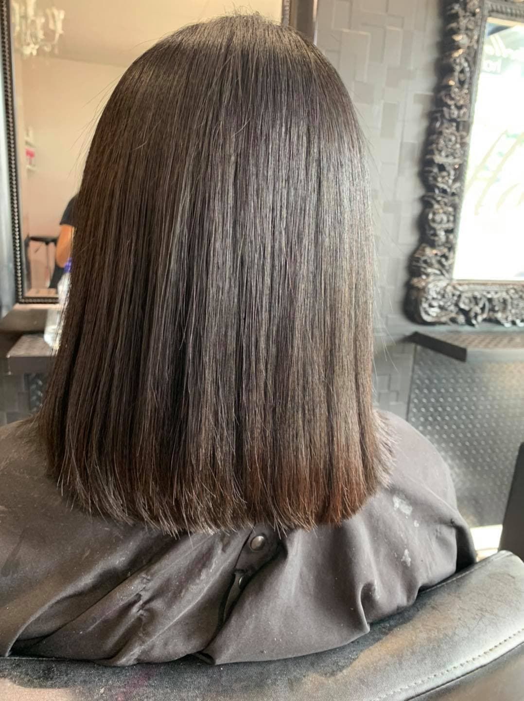 A Woman with Long Hair Is Sitting in A Chair in Front of A Mirror — Capello Hair Design in Port Macquarie, NSW