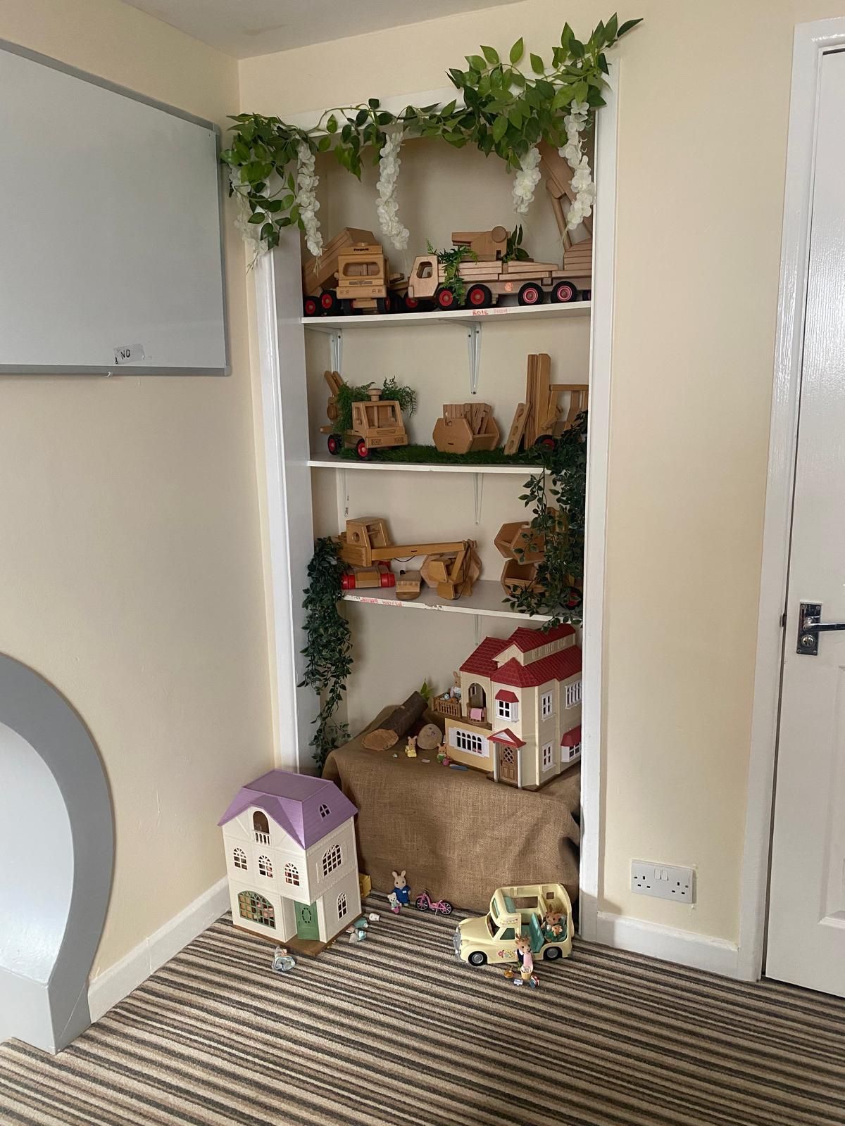 A room with a shelf full of wooden toys