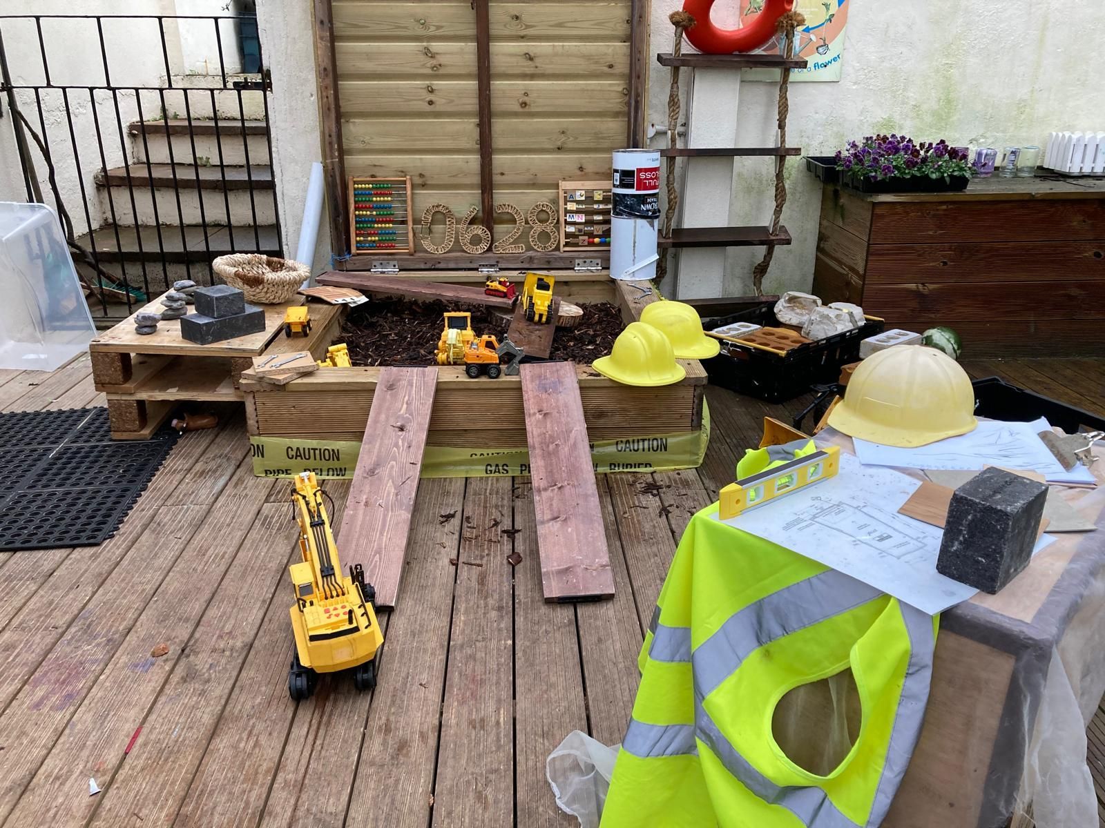 A wooden deck with toys and a yellow vest on it