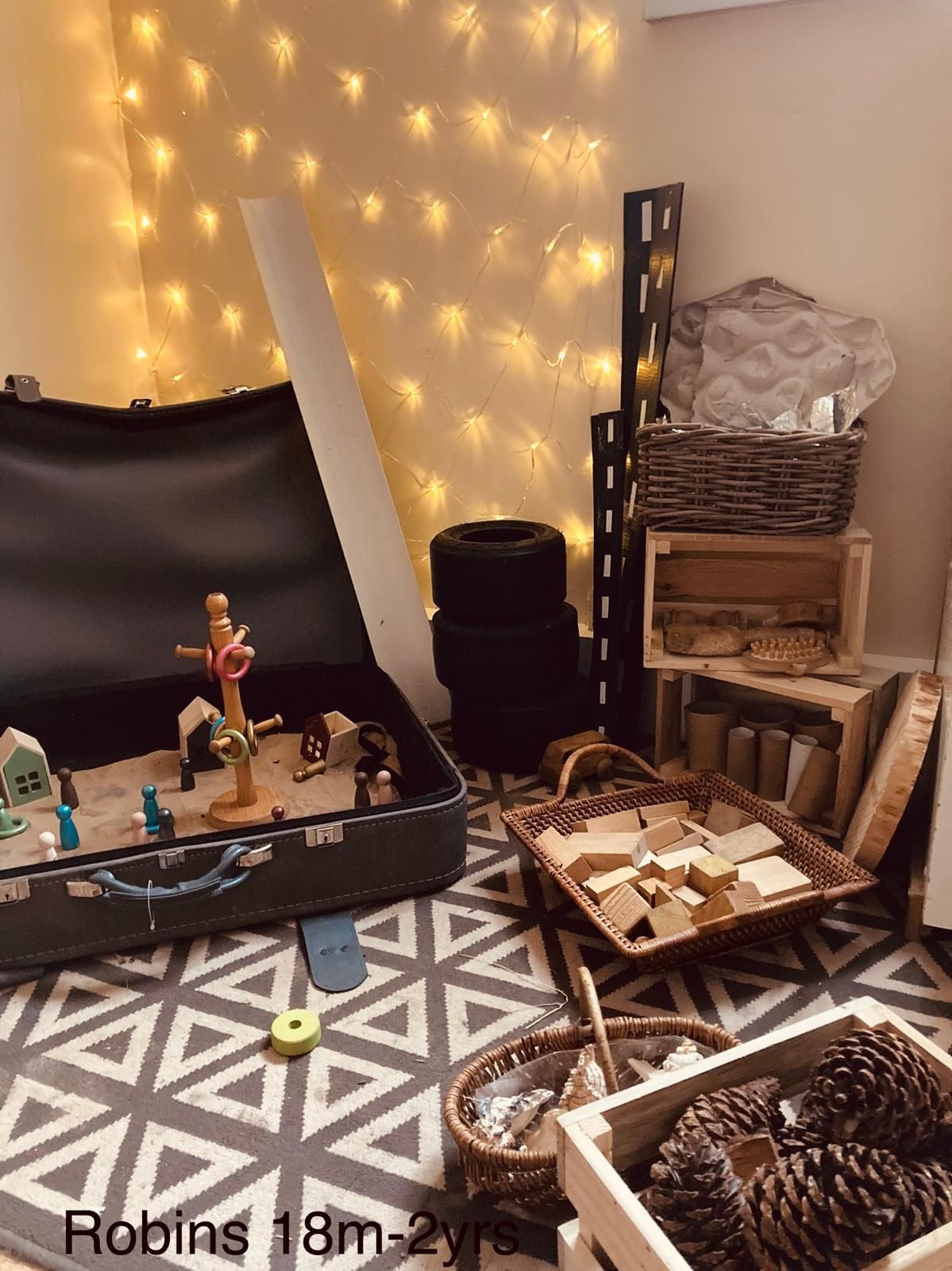 A room with a suitcase filled with toys and pine cones