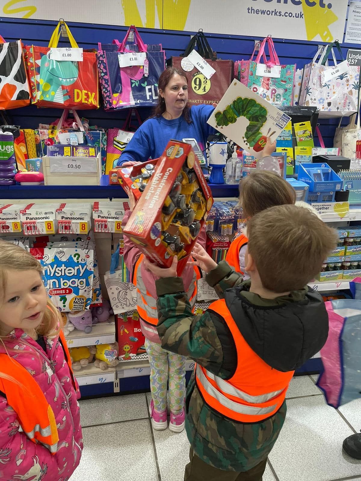 A group of children are looking at toys in a store
