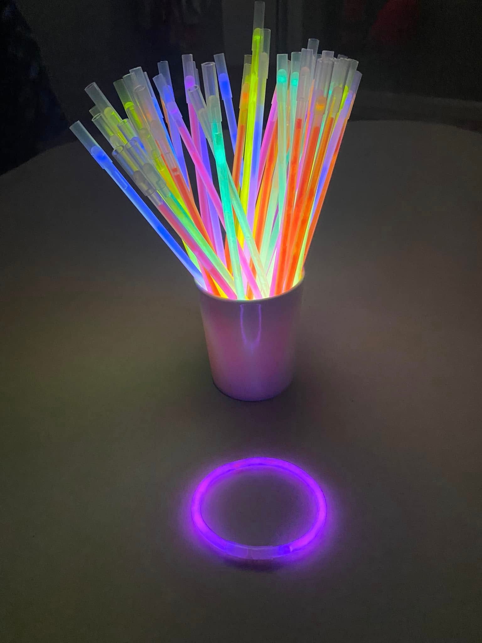 Glow in the dark sticks and a purple bracelet on a table