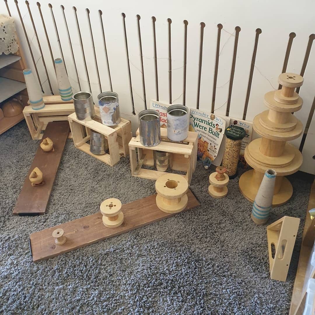 A room with a lot of wooden toys on the floor