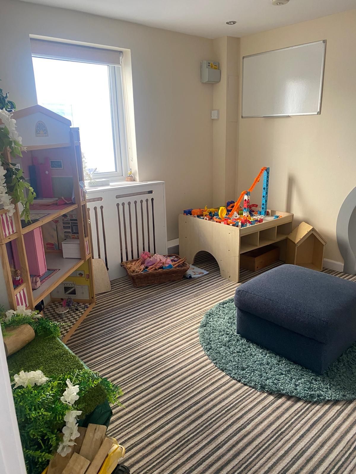 A room with a lot of toys and a white board on the wall