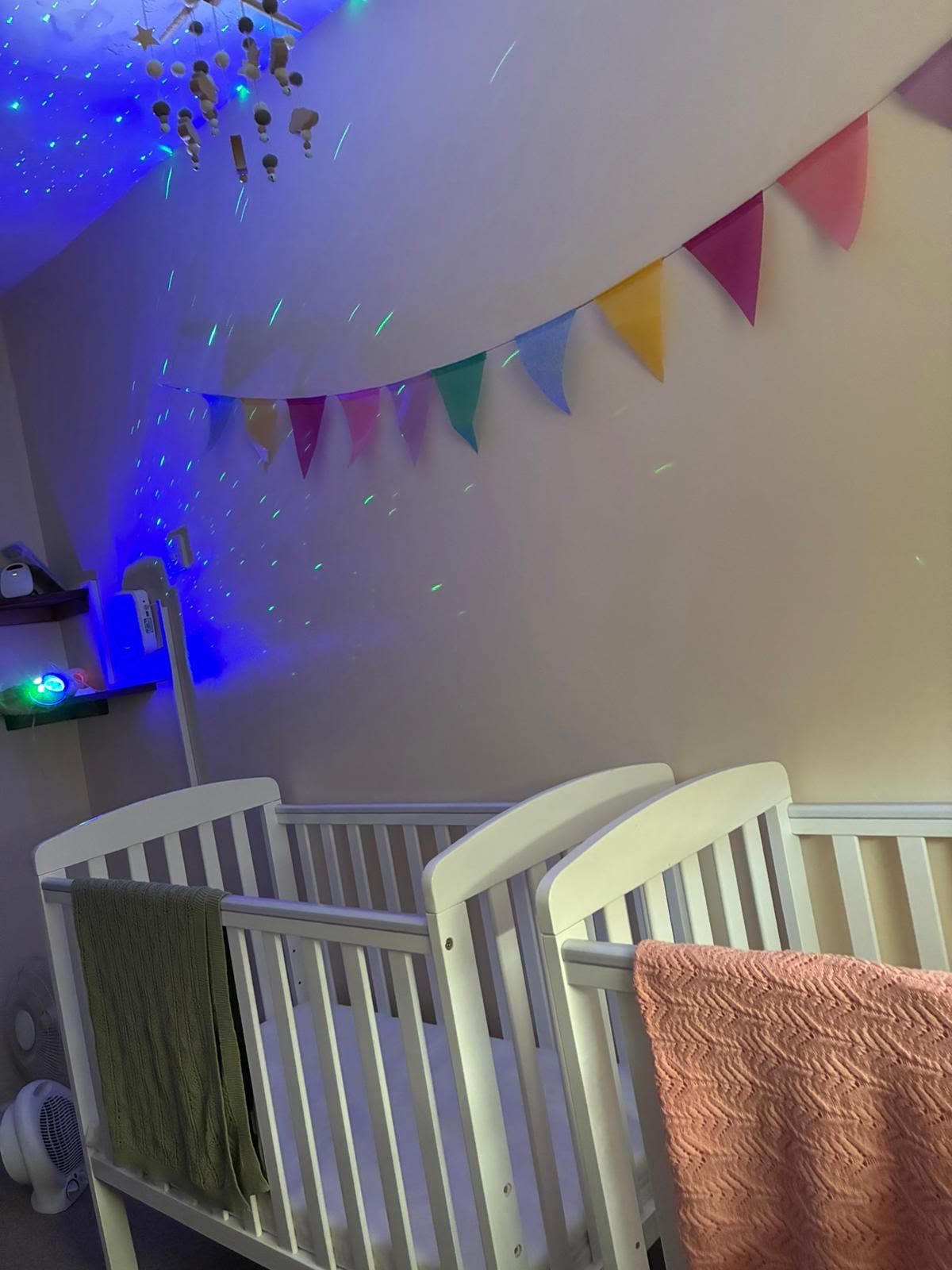 A crib in a room with a rainbow of flags on the wall
