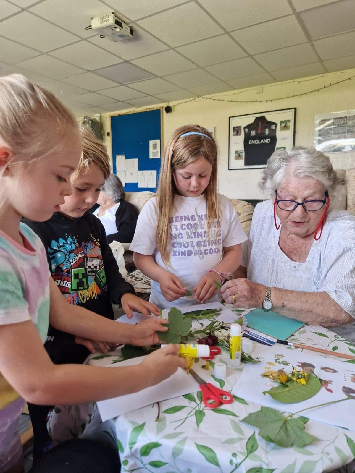 A group of children are sitting around a table making crafts