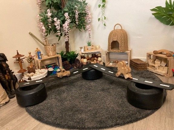 A room filled with lots of wooden toys and tires.