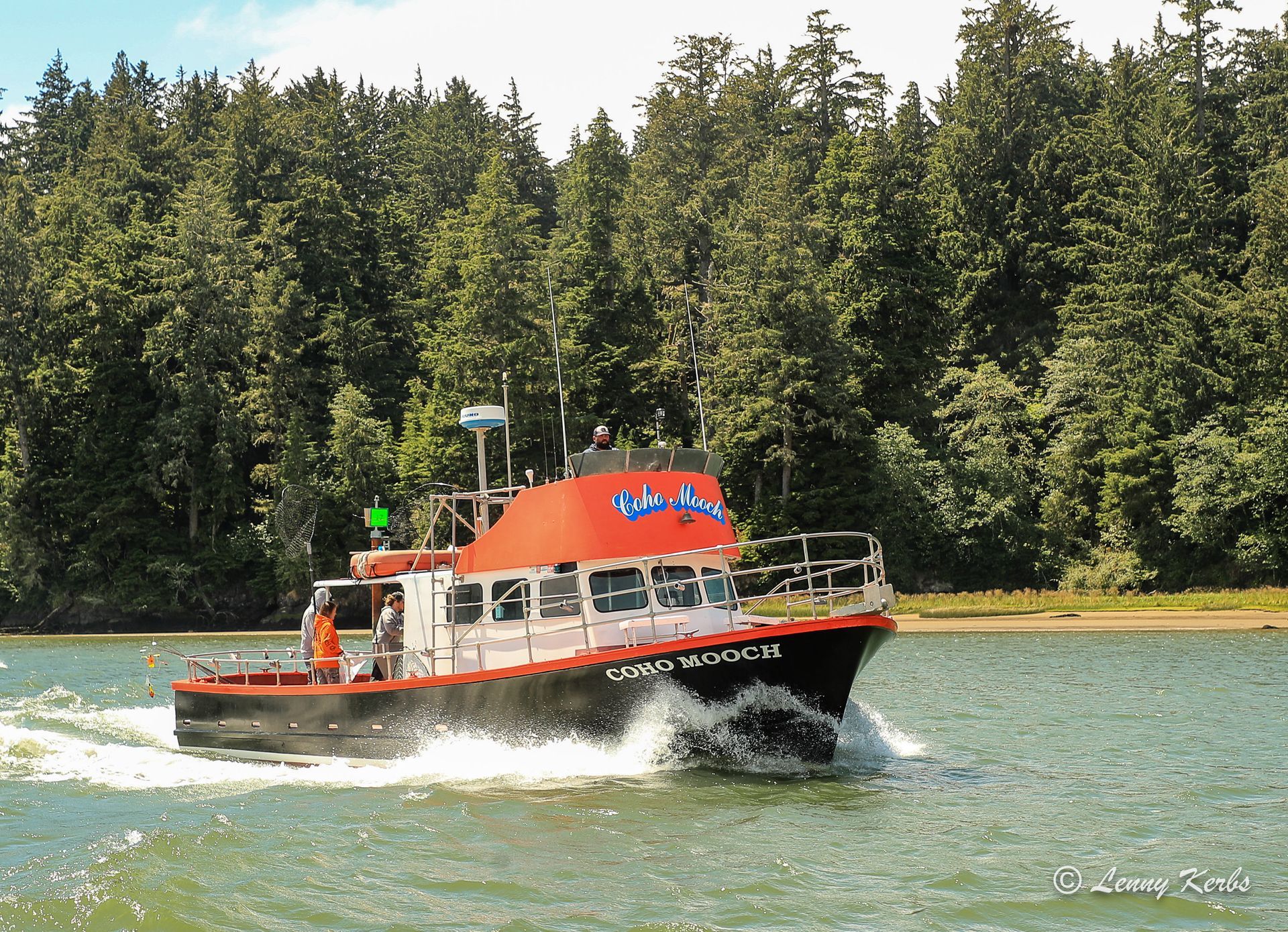 A boat with a red top is floating on a body of water