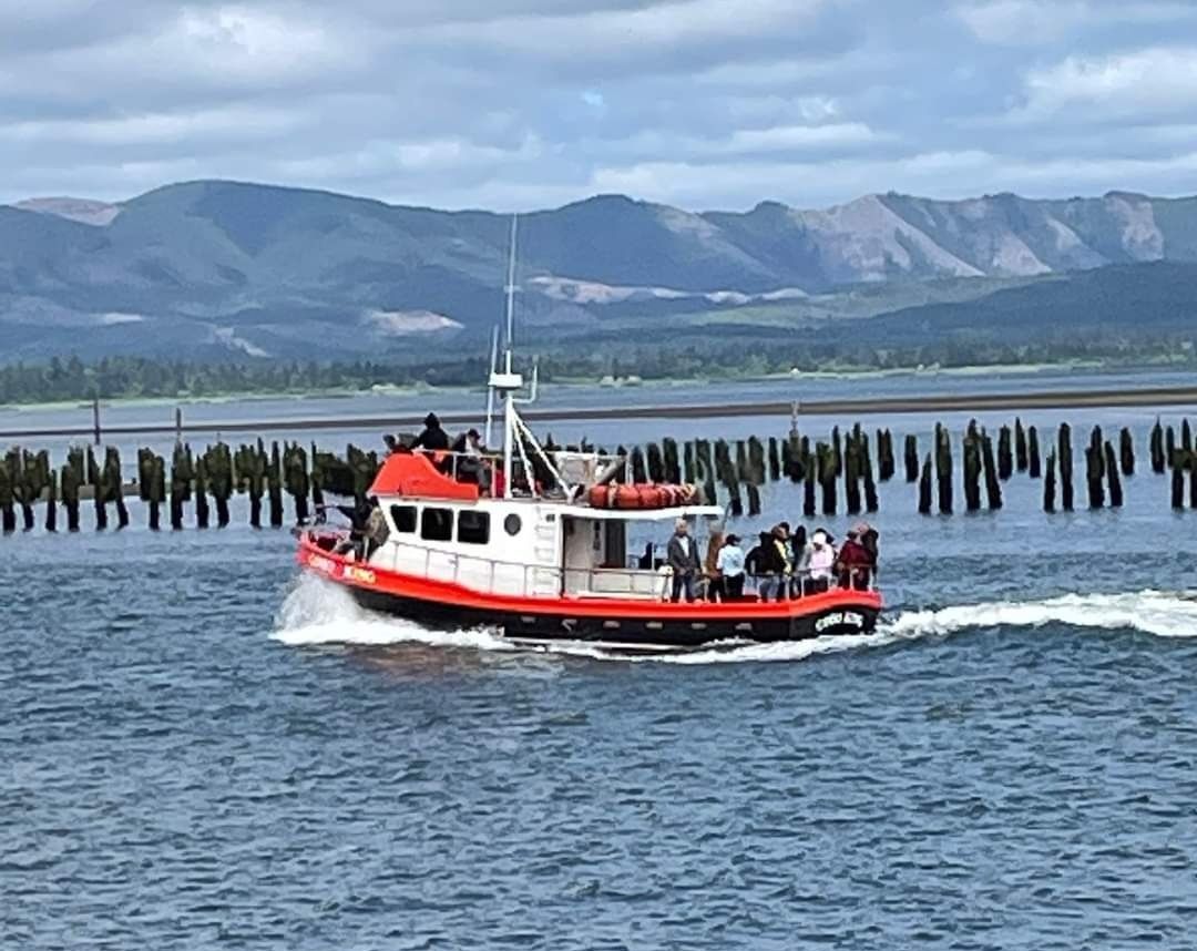 A red and white boat is floating on top of a body of water.
