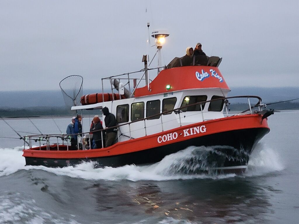 A red and white boat with the name coho king on it
