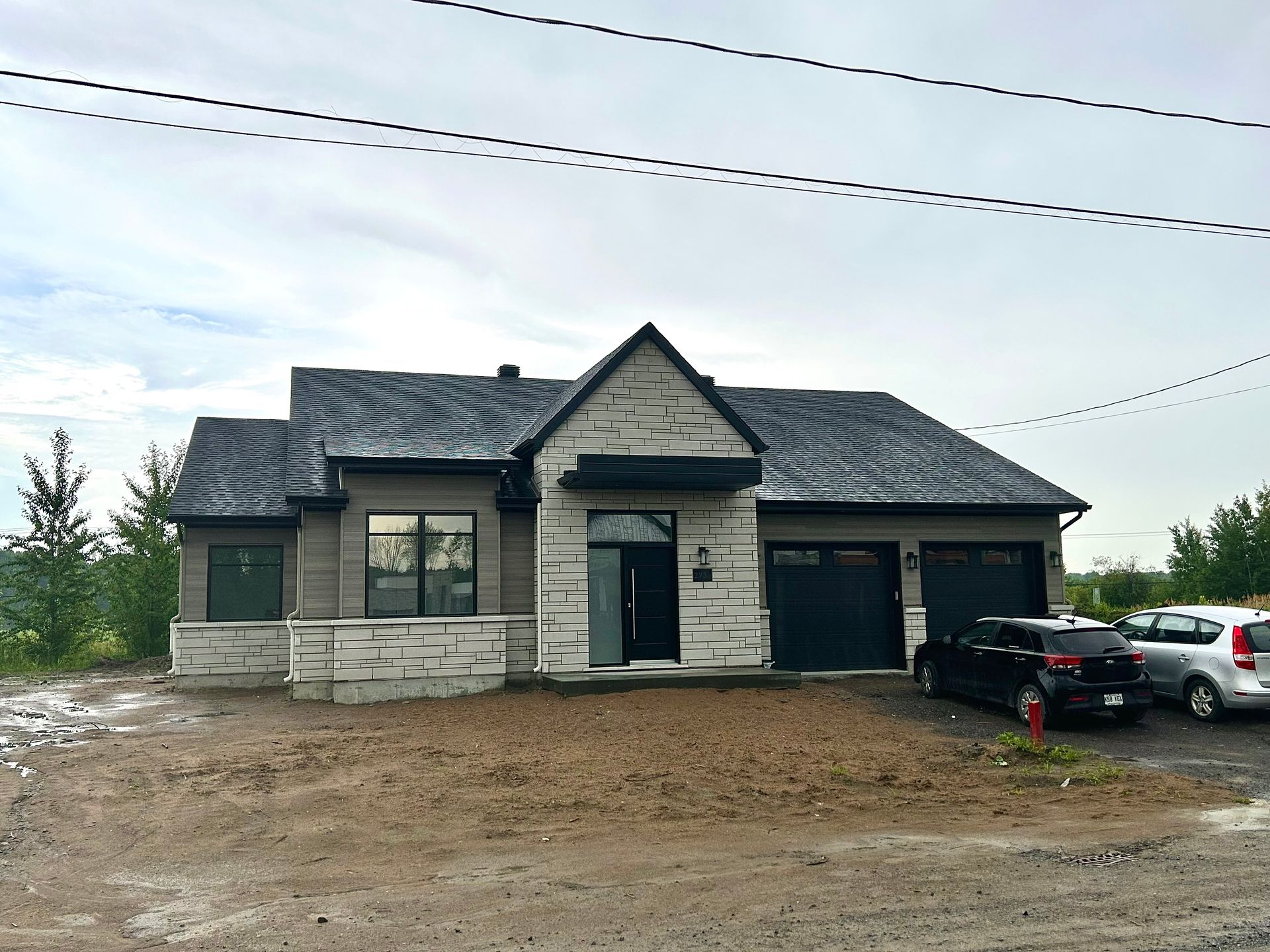 Une maison avec un camion noir garé devant.