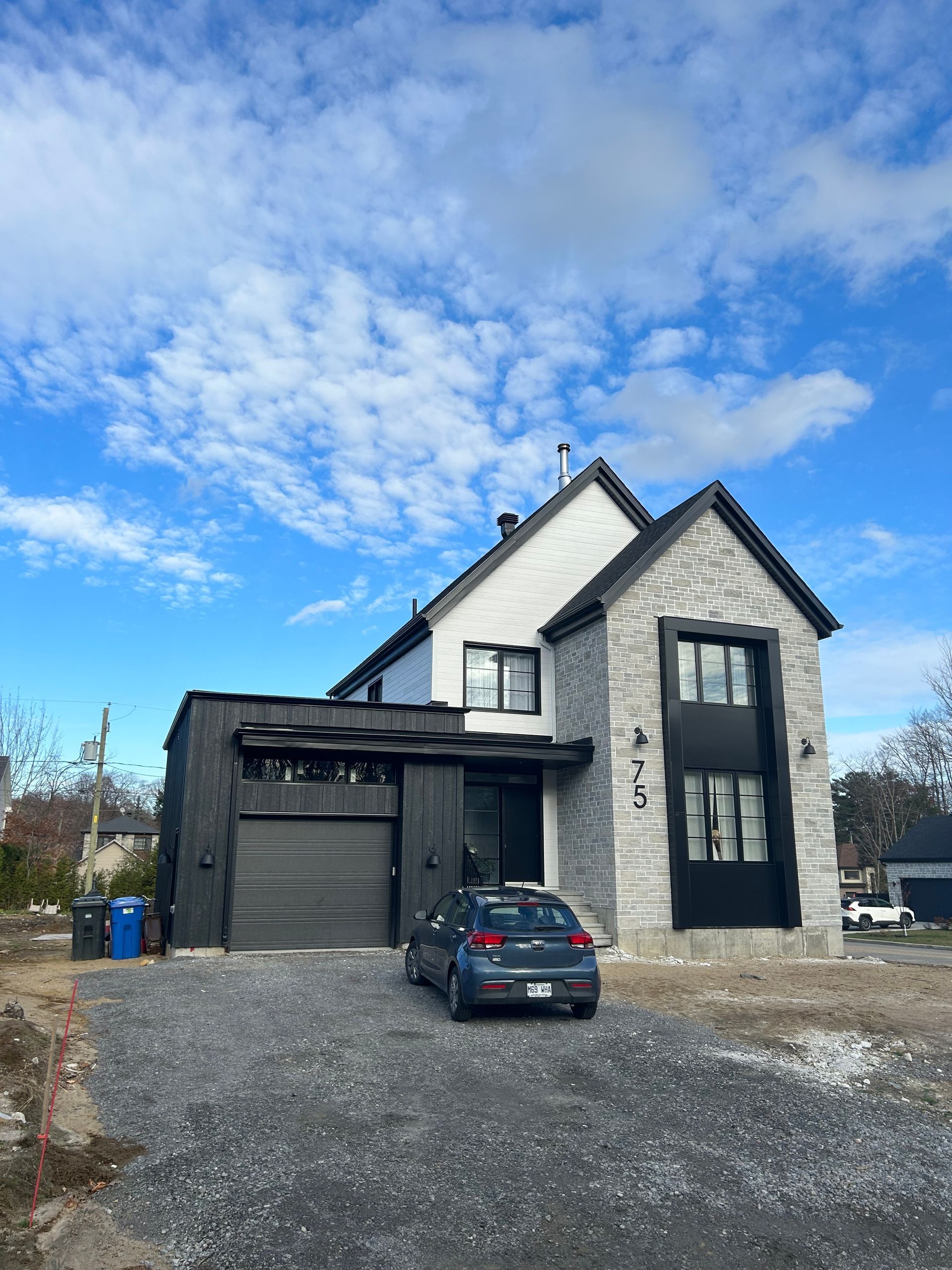 Une voiture est garée devant une grande maison.