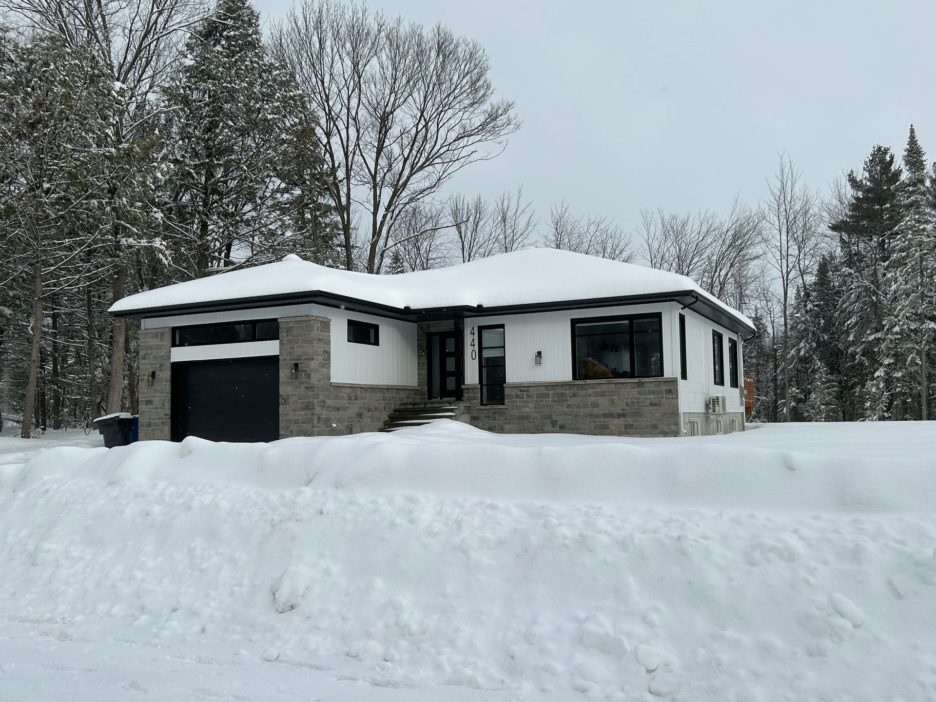 Une maison est assise au milieu d'un champ couvert de neige.