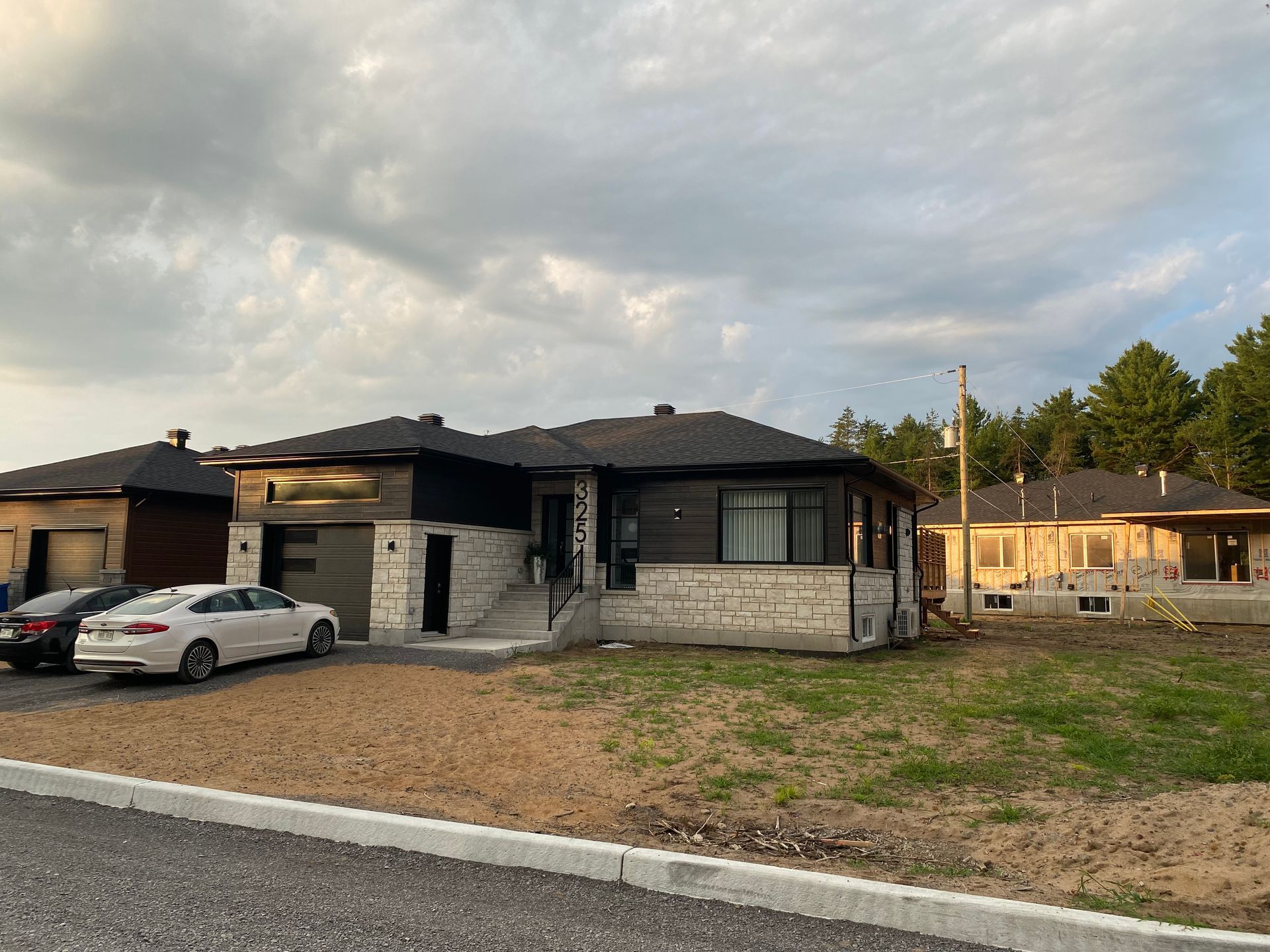 Quelques voitures sont garées devant une maison.