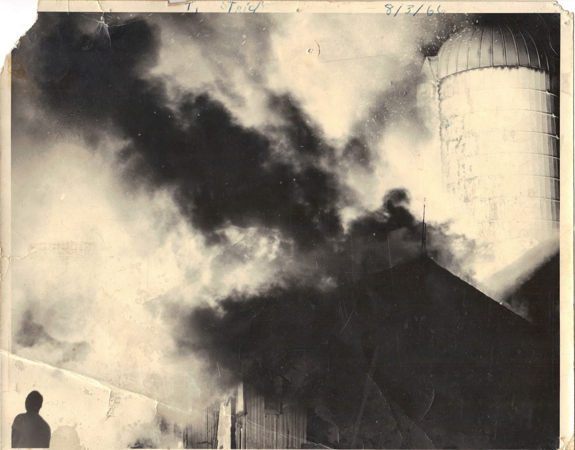 A black and white photo of smoke coming out of a building