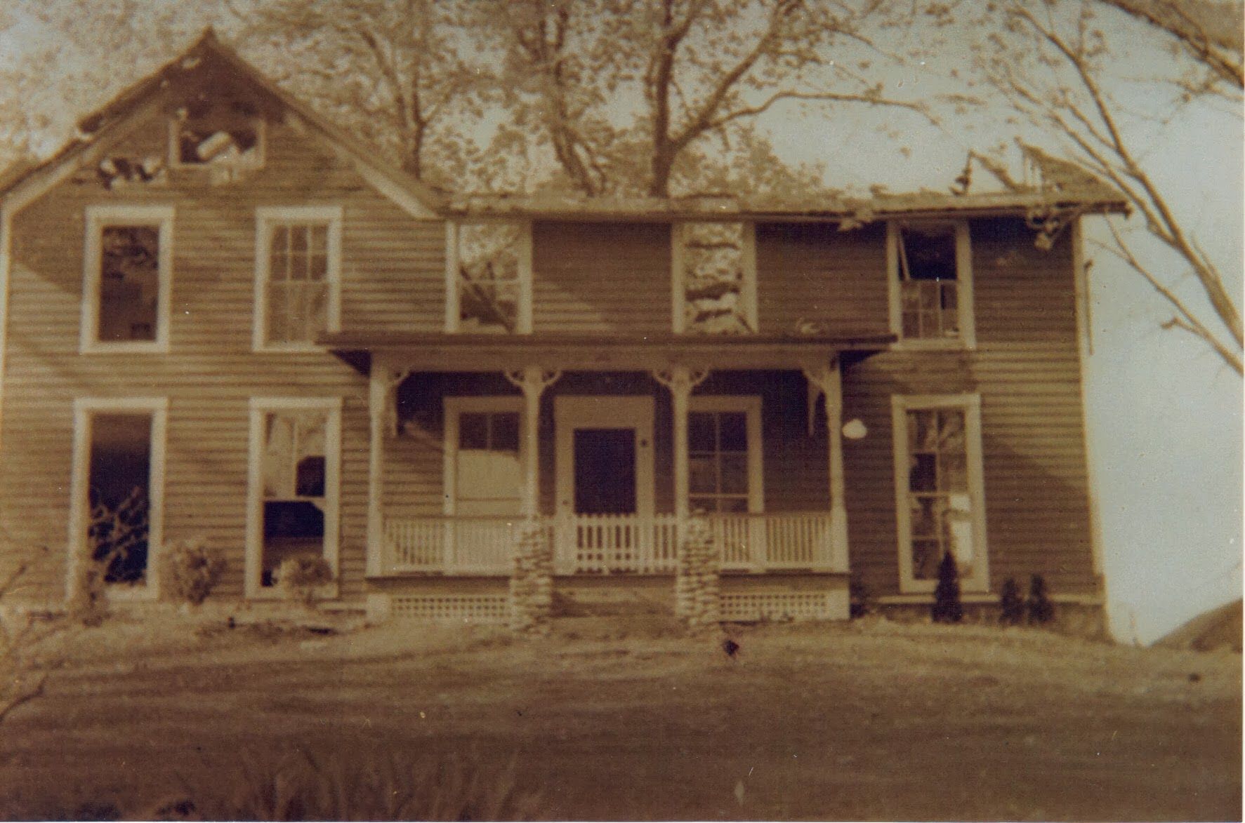 A black and white photo of a house with a porch