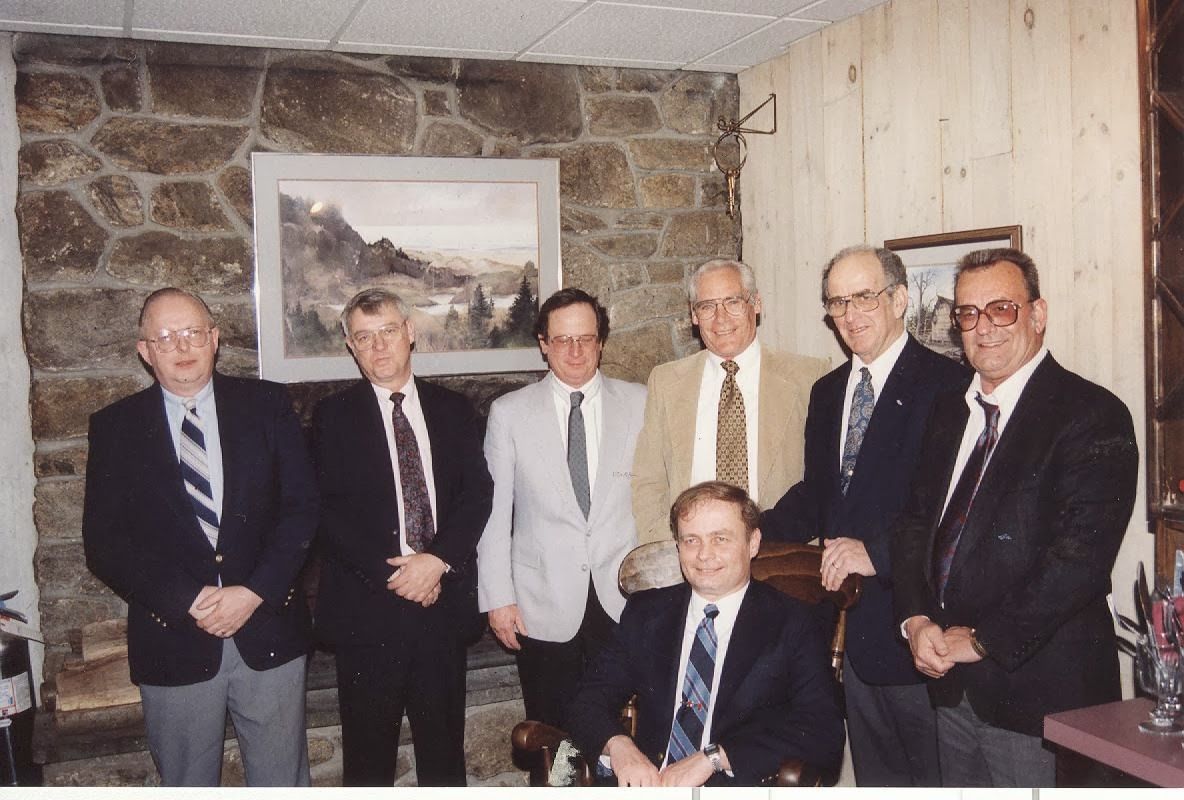 A group of men in suits and ties pose for a photo